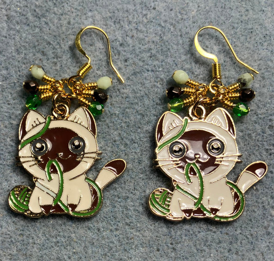 Brown, white, and green enamel cat charm earrings adorned with small dangling brown, white, and green Czech glass beads.