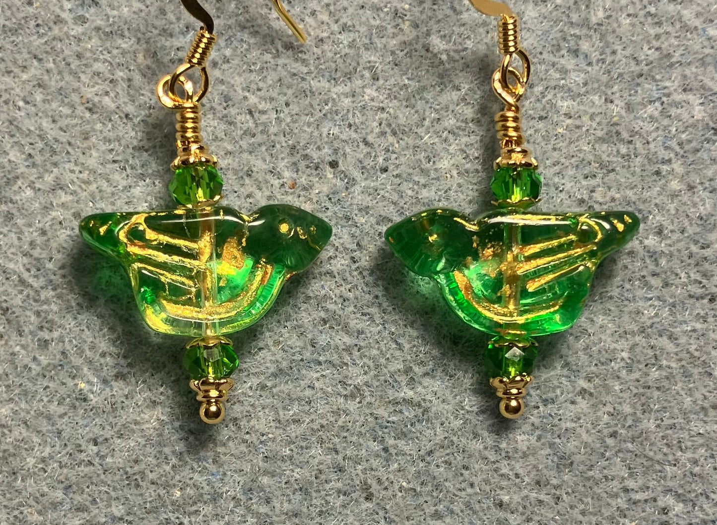 Translucent green (with gold wash) Czech glass bird bead earrings adorned with green Chinese crystal beads.
