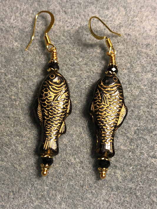 Black (with gold inlay) Czech glass fish bead earrings adorned with black Chinese crystal beads.