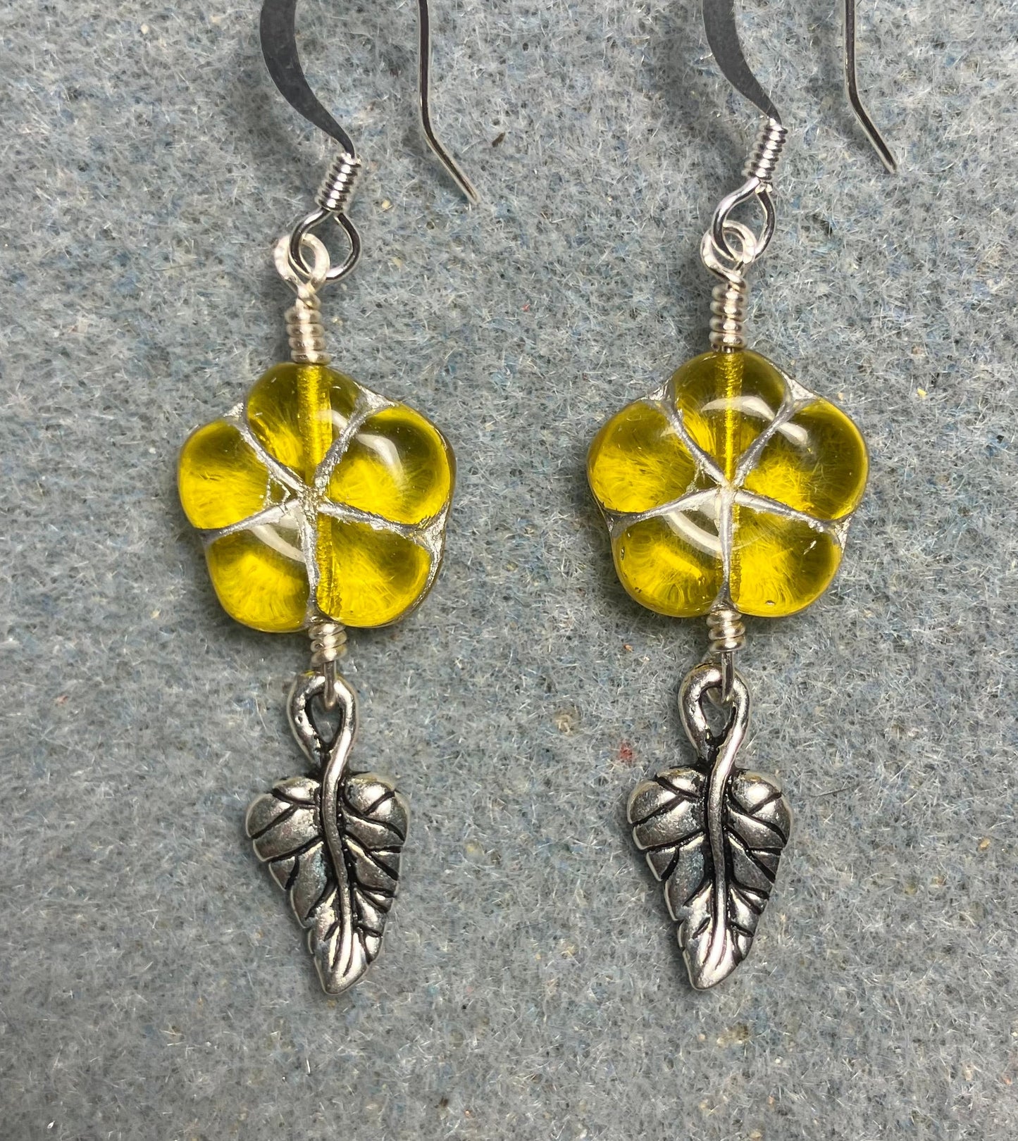 Yellow (with silver inlay) Czech glass puffy flower bead earrings adorned with silver Tierracast leaf charms.