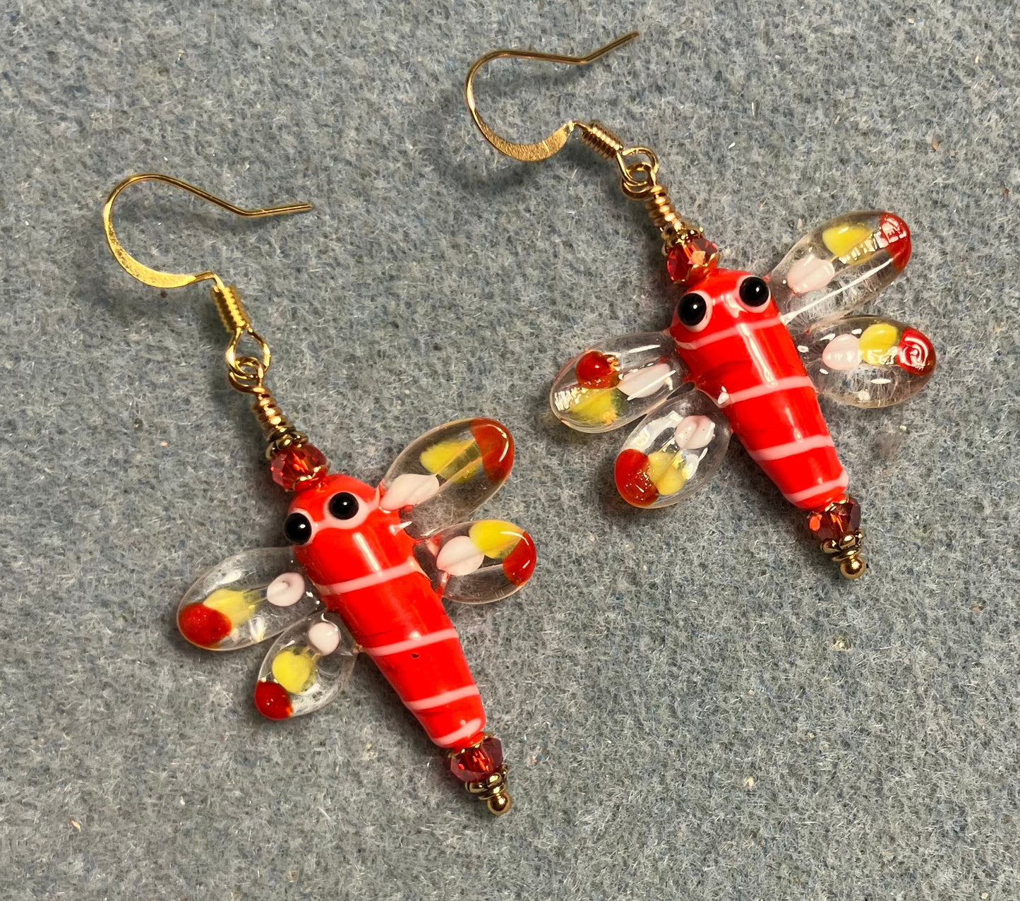 Red, white, and yellow lamp work dragonfly bead earrings adorned with red Chinese crystal beads.
