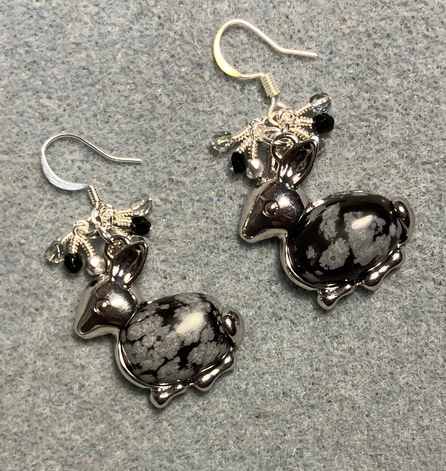 Large silver and snowflake obsidian gemstone rabbit charm earrings adorned with small dangling black, silver, and clear Czech glass beads.