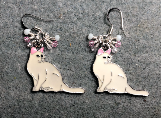 White and pink enamel cat charm earrings adorned with tiny dangling clear, pink, and white Chinese crystal beads.