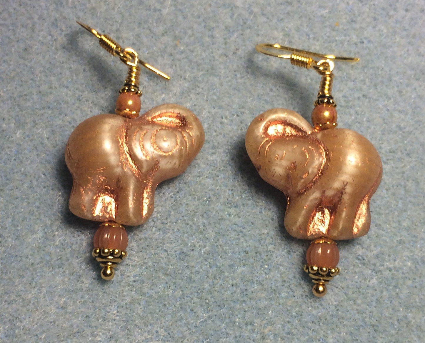 Tan and orange (with copper inlay) Czech glass elephant bead earrings adorned with orange Czech glass beads.