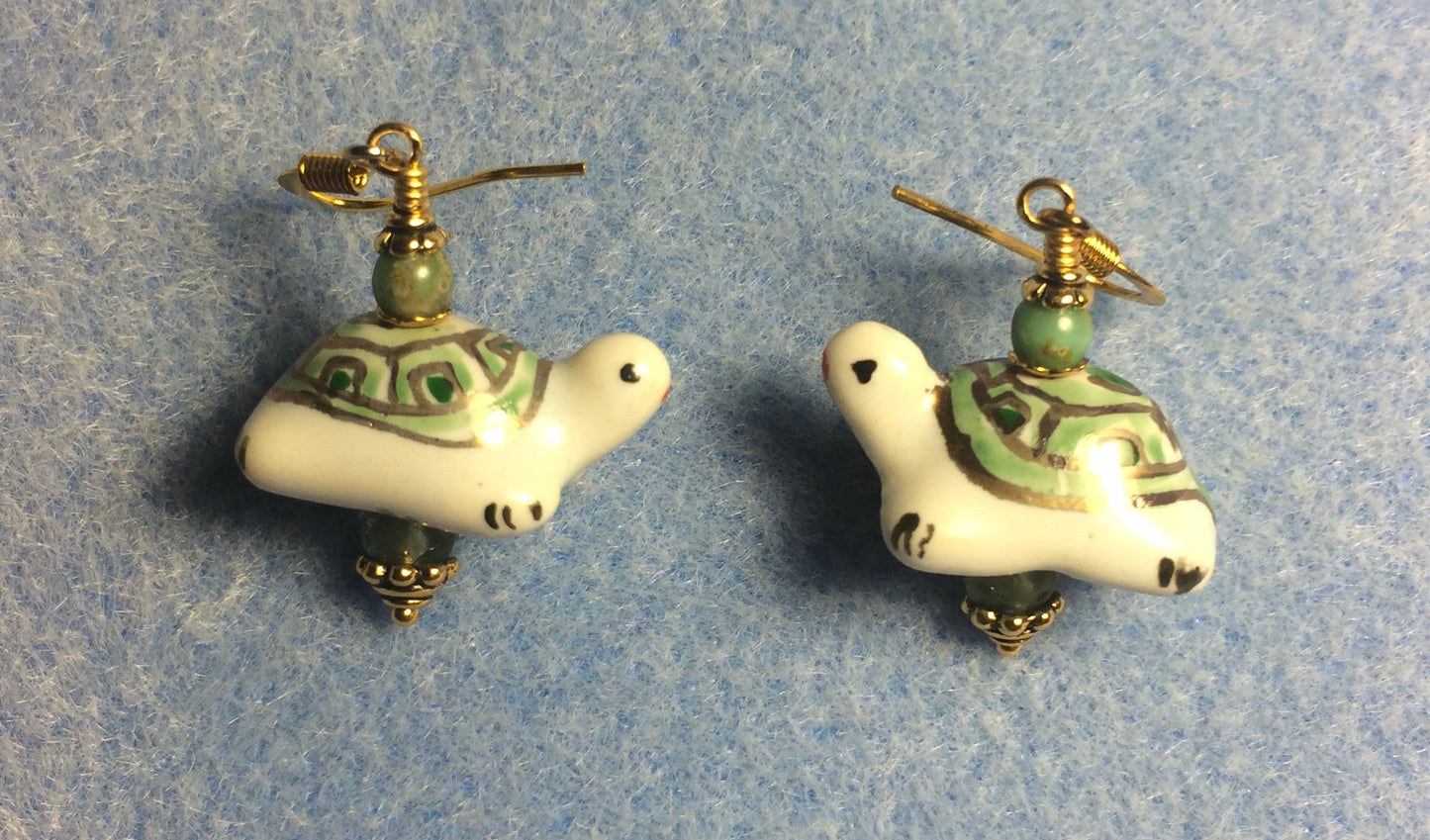 Green and white ceramic turtle bead earrings adorned with green Czech glass beads.