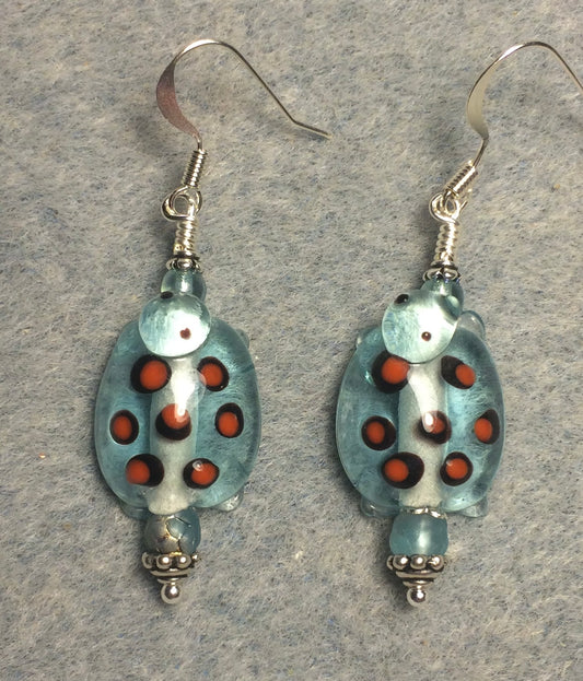 Light turquoise with orange spots lamp work turtle bead earrings adorned with light turquoise Czech glass beads.