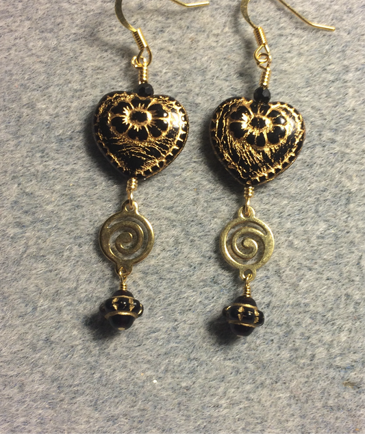 Opaque black (with gold inlay) Czech glass heart bead earrings adorned with gold swirly links and black Czech glass Saturn beads.
