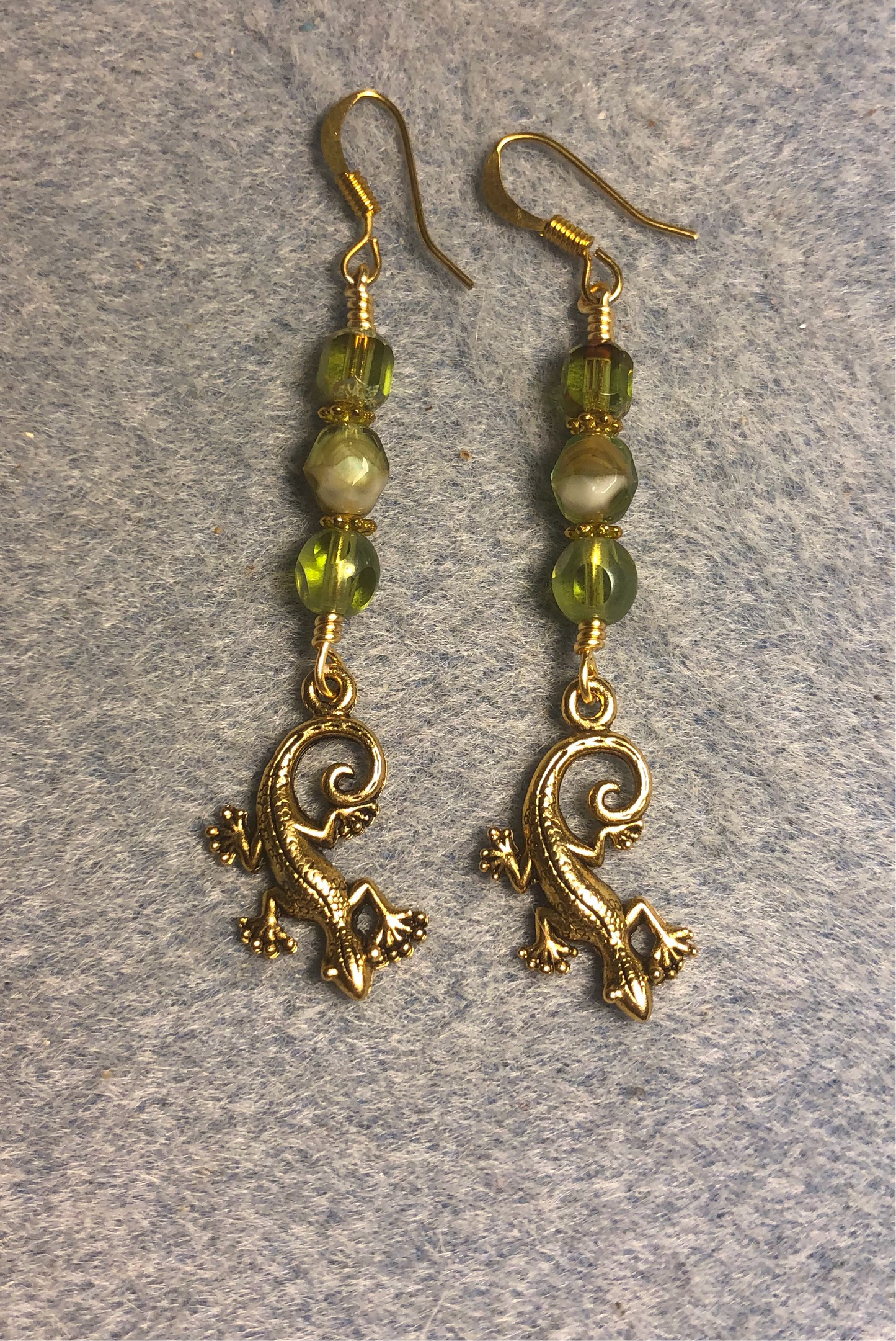 Small gold lizard charm earrings adorned with olive green Czech glass beads