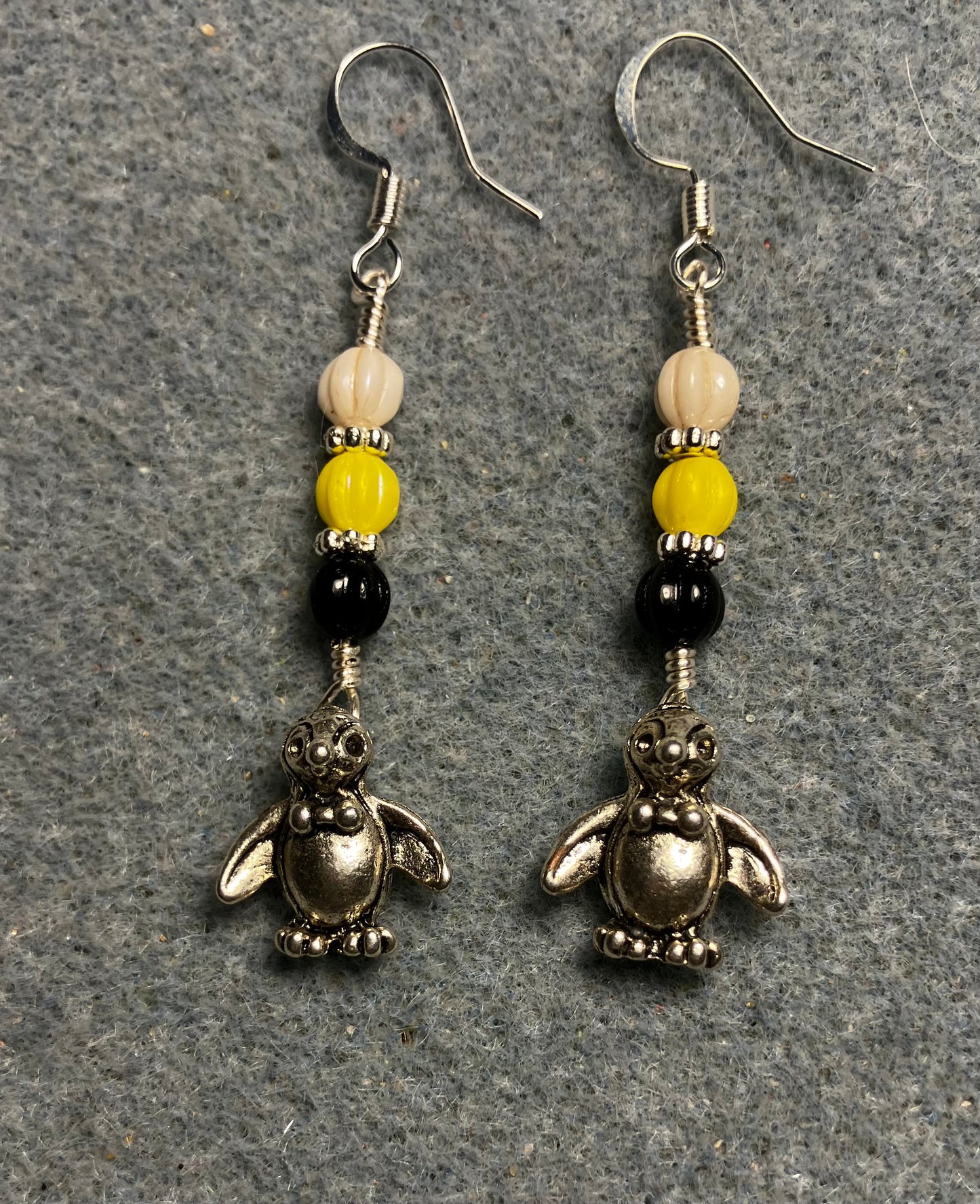 Small silver silly penguin charm earrings adorned with small black, yellow, and white Czech glass melon beads
