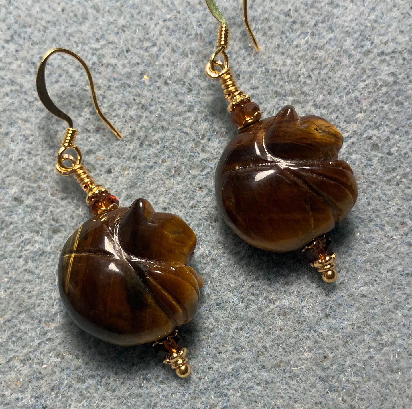 Tigereye gemstone sleeping cat bead earrings adorned with dark amber Chinese crystal beads.