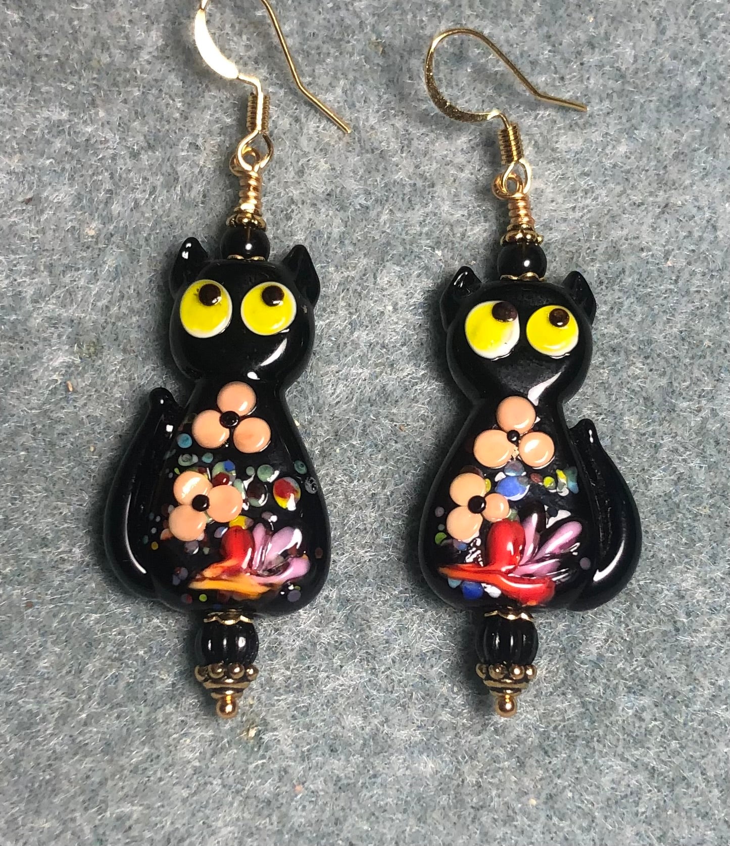 Black, tan, and yellow lamp work cat bead earrings adorned with black Czech glass beads.