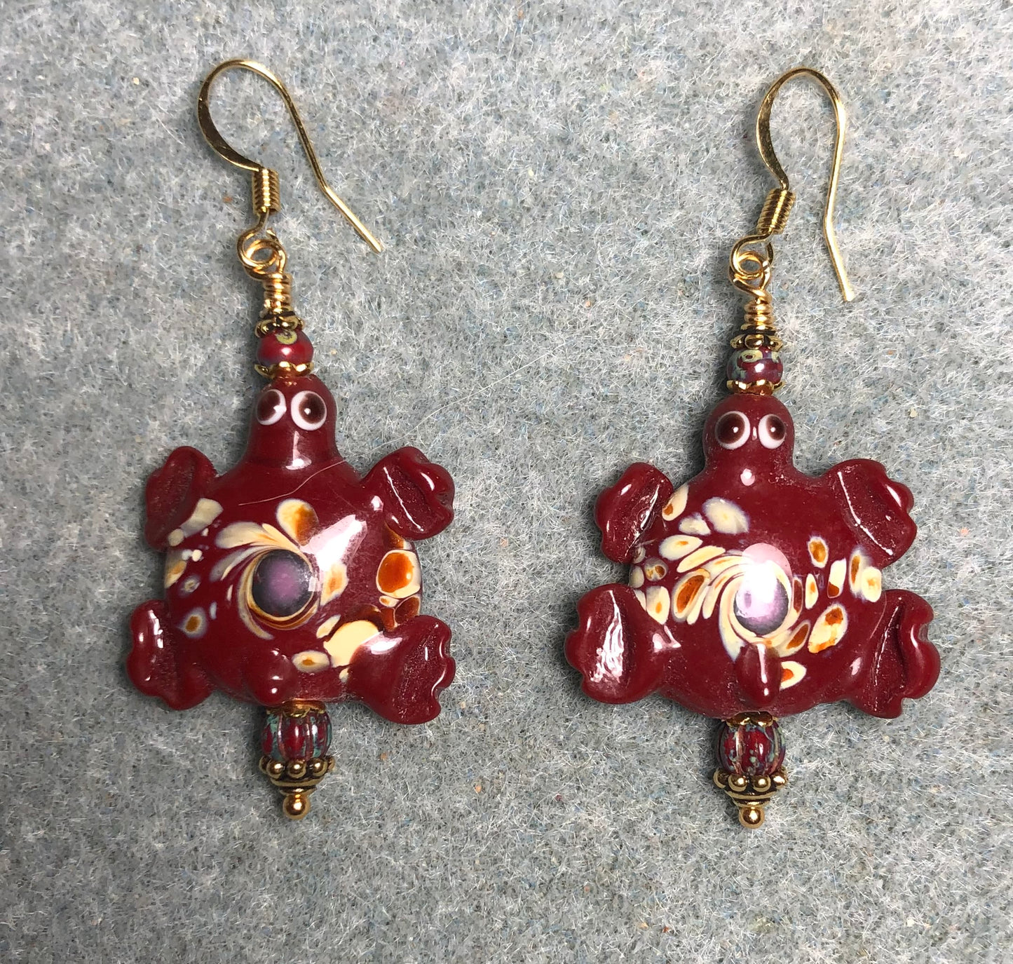 Large spotted dark red lamp work turtle bead earrings adorned with dark red Picasso Czech glass beads.