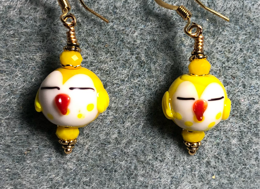 Small yellow and white lamp work sleepy owl bead earrings adorned with yellow Chinese crystal beads.