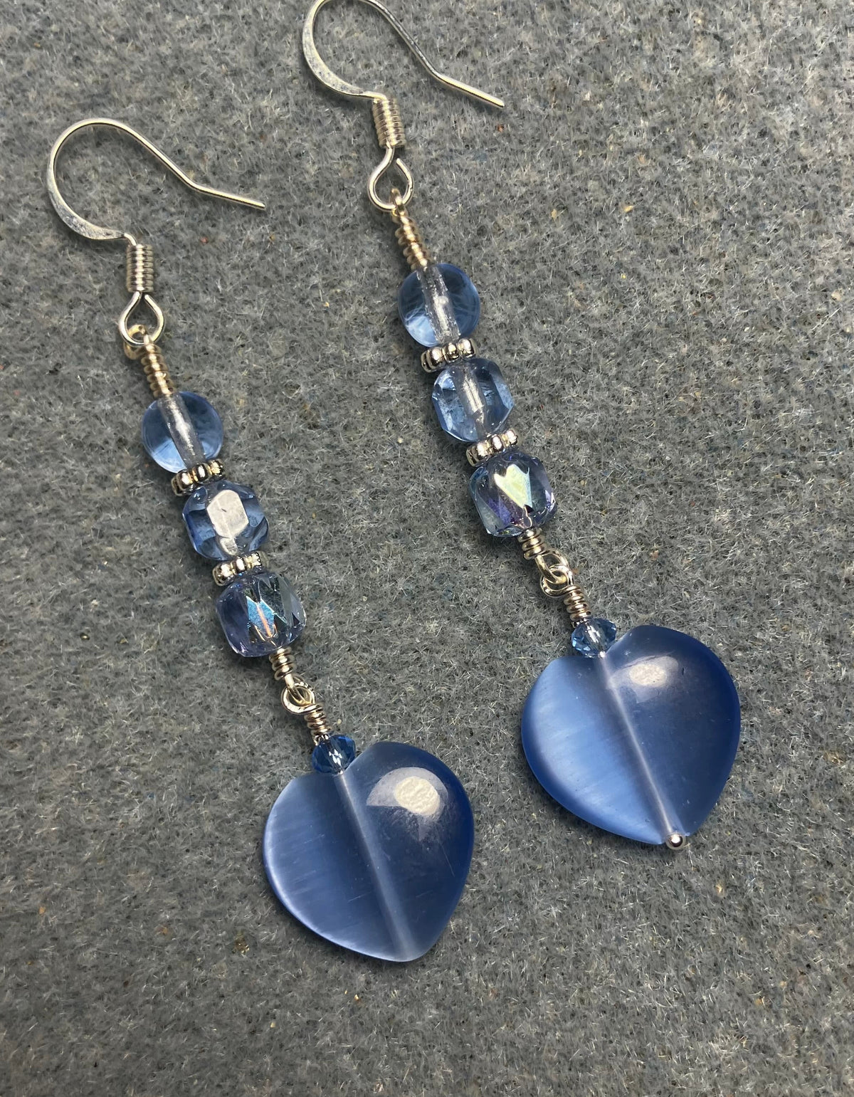Light blue fiber optic (cat’s eye) Czech glass heart bead earrings adorned with light blue Czech glass beads.