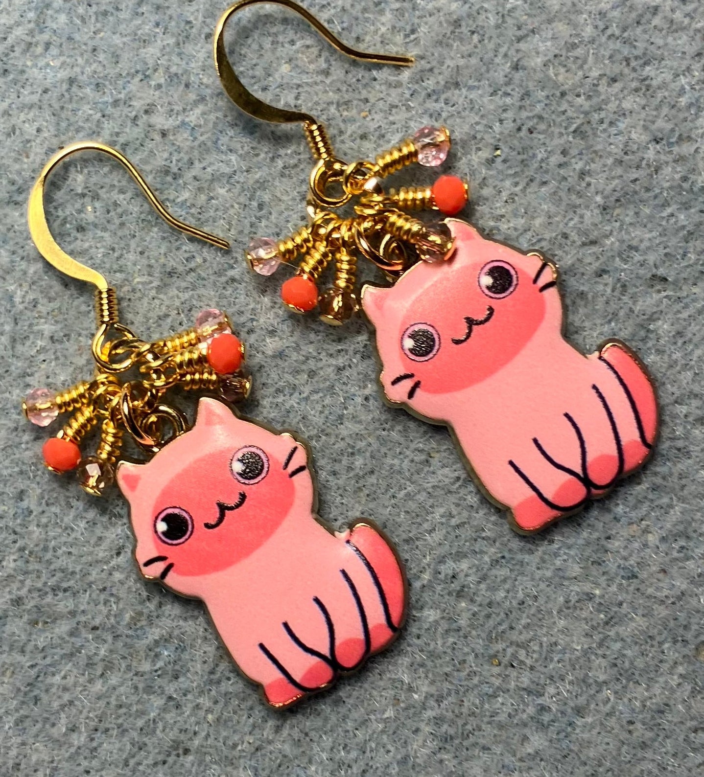 Pink enamel cat charm earrings adorned with tiny dangling pink and coral Chinese crystal beads.