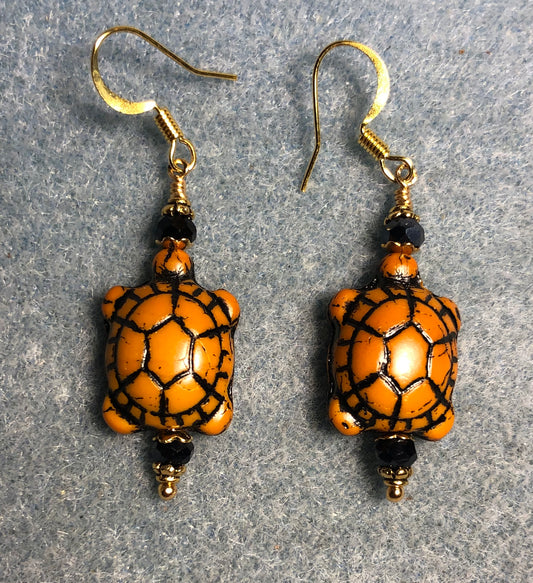 Opaque amber(with black wash) Czech glass turtle bead earrings adorned with black Chinese crystal beads.