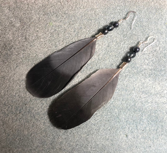 Gray and black gull feather earrings adorned with gray Czech glass beads.