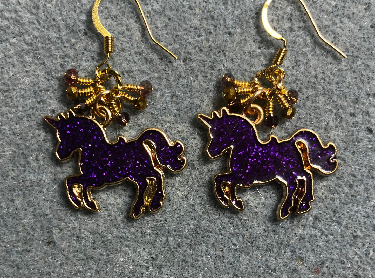 Purple and gold enamel sparkly unicorn charm earrings adorned with tiny dangling purple and gold Chinese crystal beads.