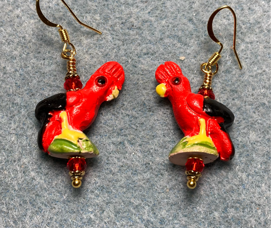 Red, black, and green ceramic cockatoo bead earrings adorned with red Chinese crystal beads.