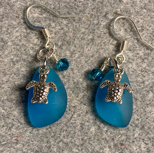 Small dark turquoise sea glass pendant bead earrings adorned with small silver sea turtle charms and dark turquoise Chinese crystal beads.