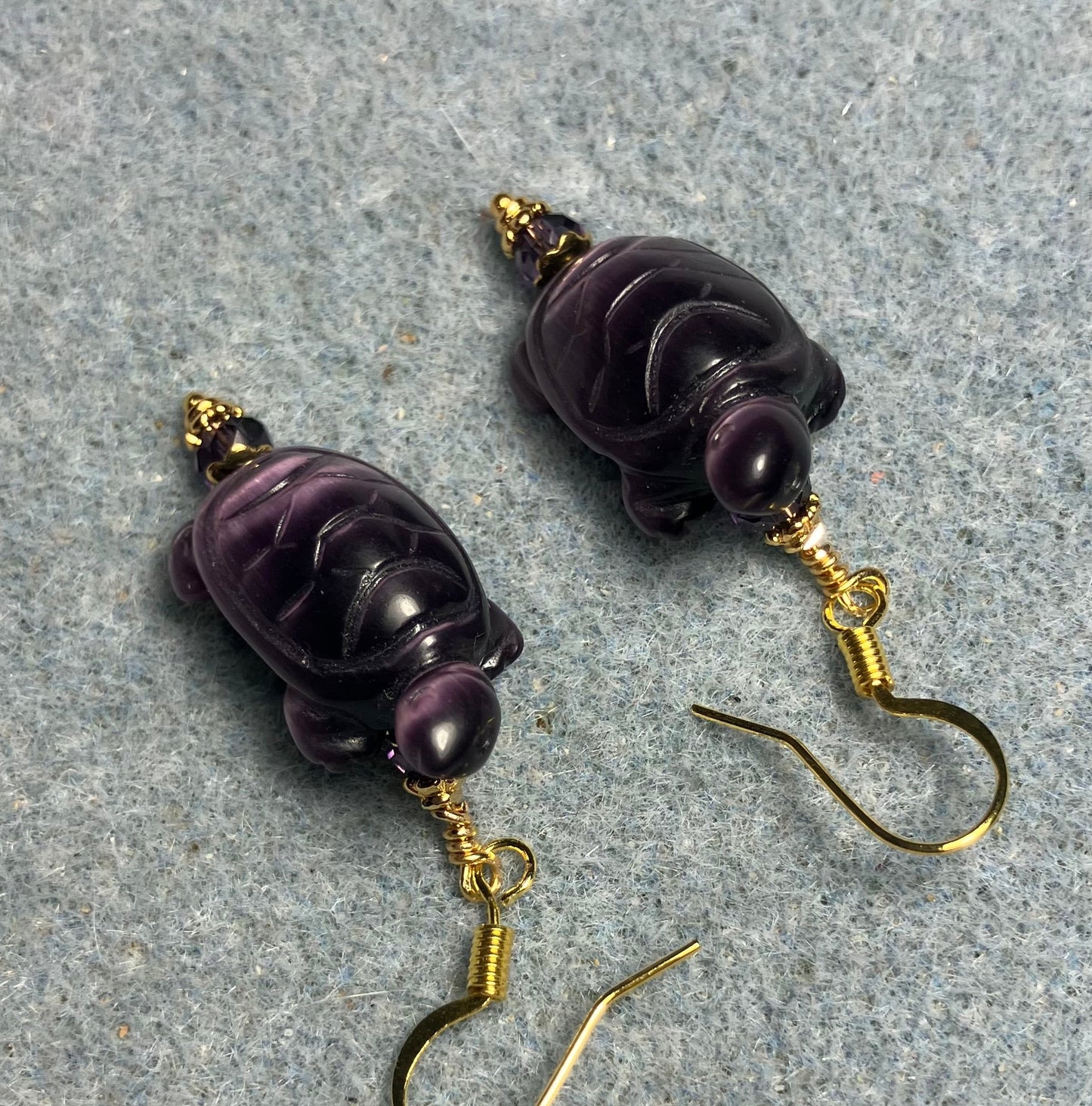 Purple fiber optic (cat’s eye) turtle bead earrings adorned with purple Chinese crystal beads.