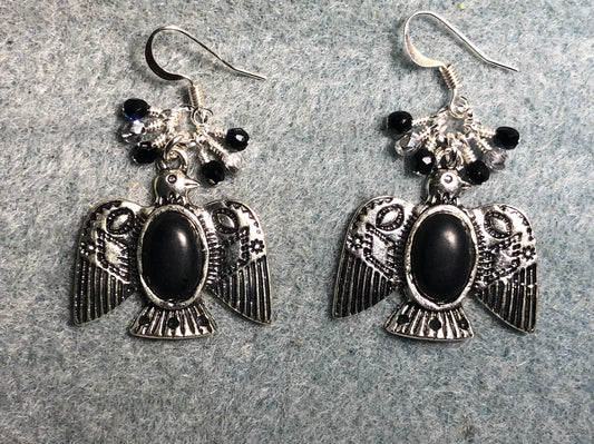 Silver and black onyx gemstone eagle charm earrings adorned with tiny dangling black and silver beads.