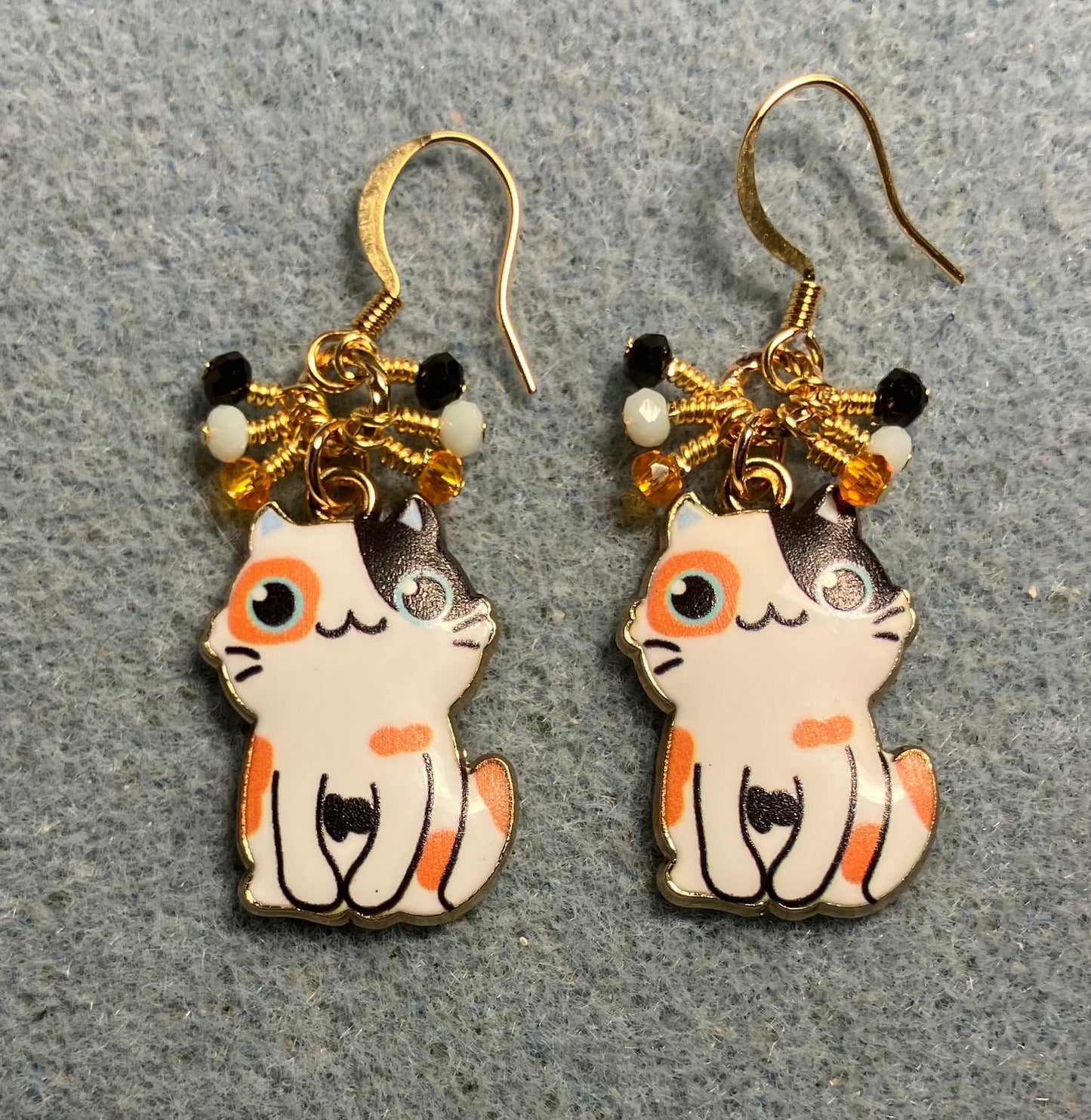 Orange, white, and black enamel calico cat charm earrings adorned with tiny dangling orange, white, and black Chinese crystal beads.