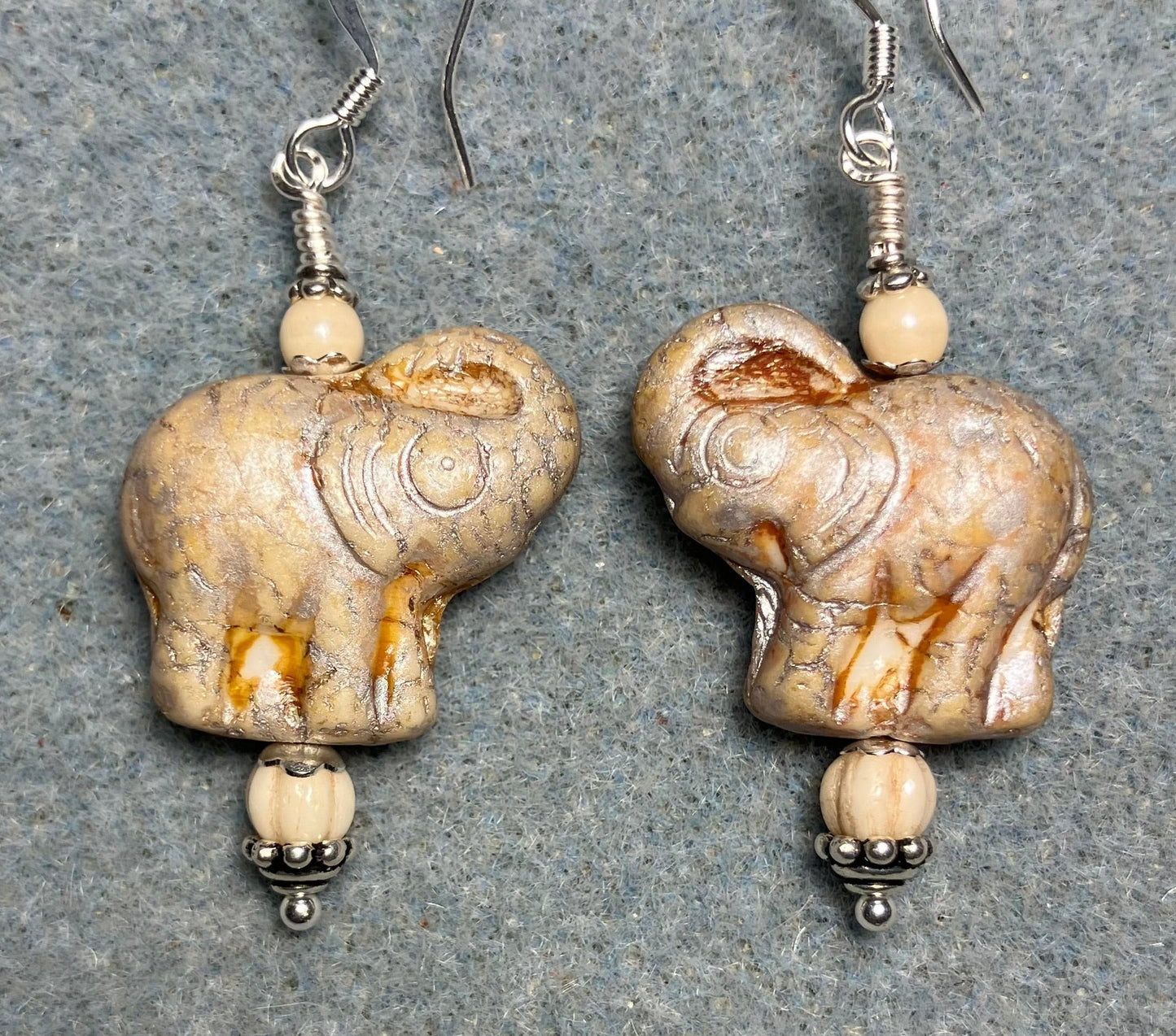 Creamy beige (with silver inlay) Czech glass elephant bead earrings adorned with cream Czech glass beads.