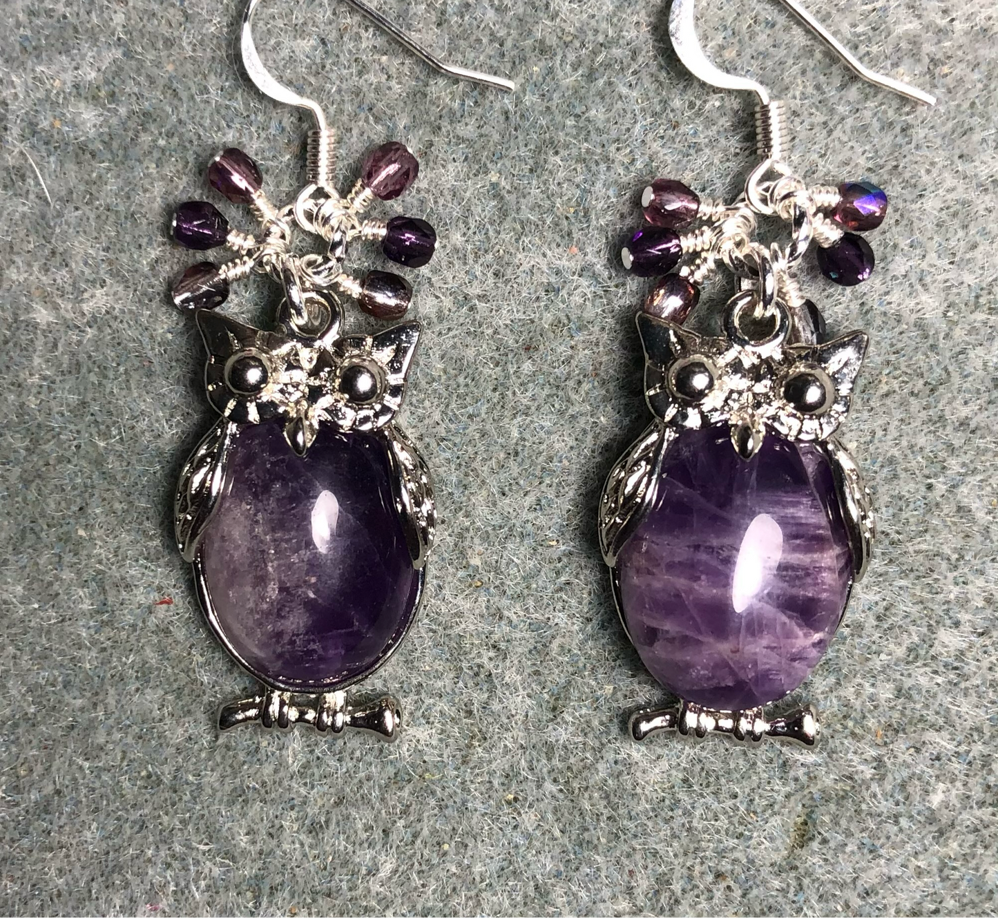Large silver and amethyst gemstone owl charm earrings adorned with small dangling purple Czech glass beads.