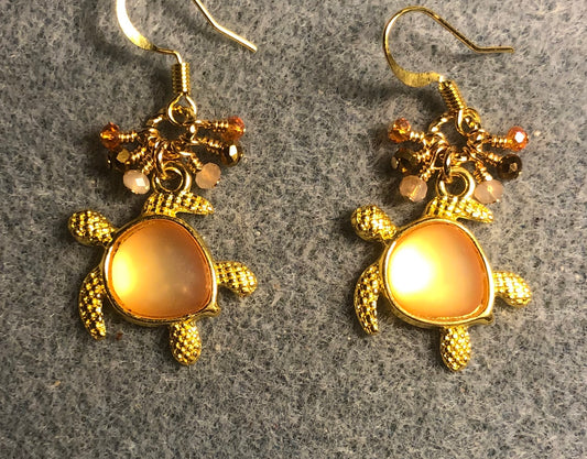 Gold and orange fiber optic sea turtle charm earrings adorned with tiny dangling peach, orange, and gold Chinese crystal beads.