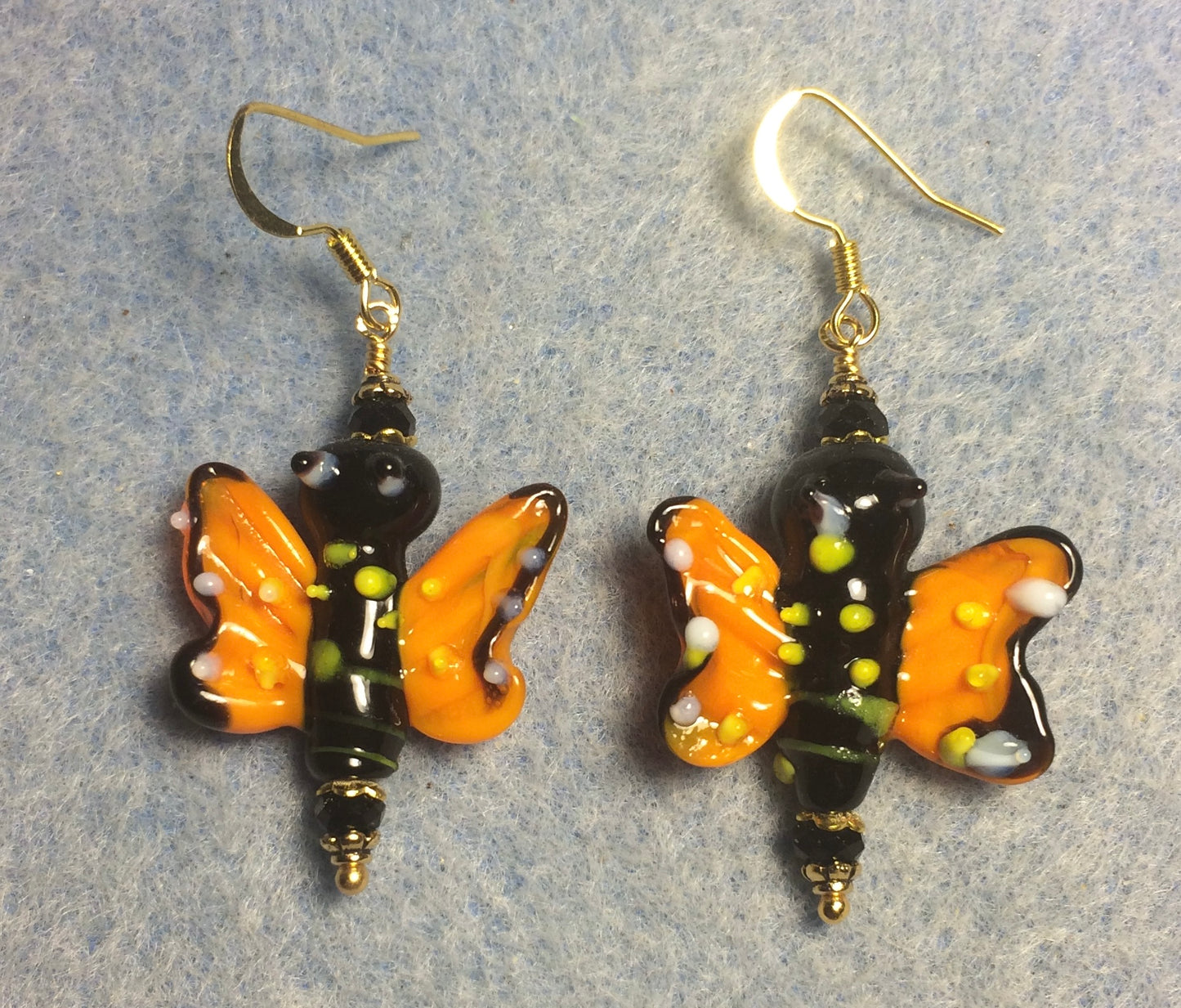 Orange, black, and yellow lamp work butterfly bead earrings adorned with black Chinese crystal beads.