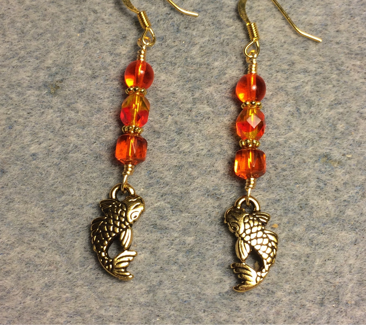 Gold koi charm earrings adorned with orange Czech glass beads