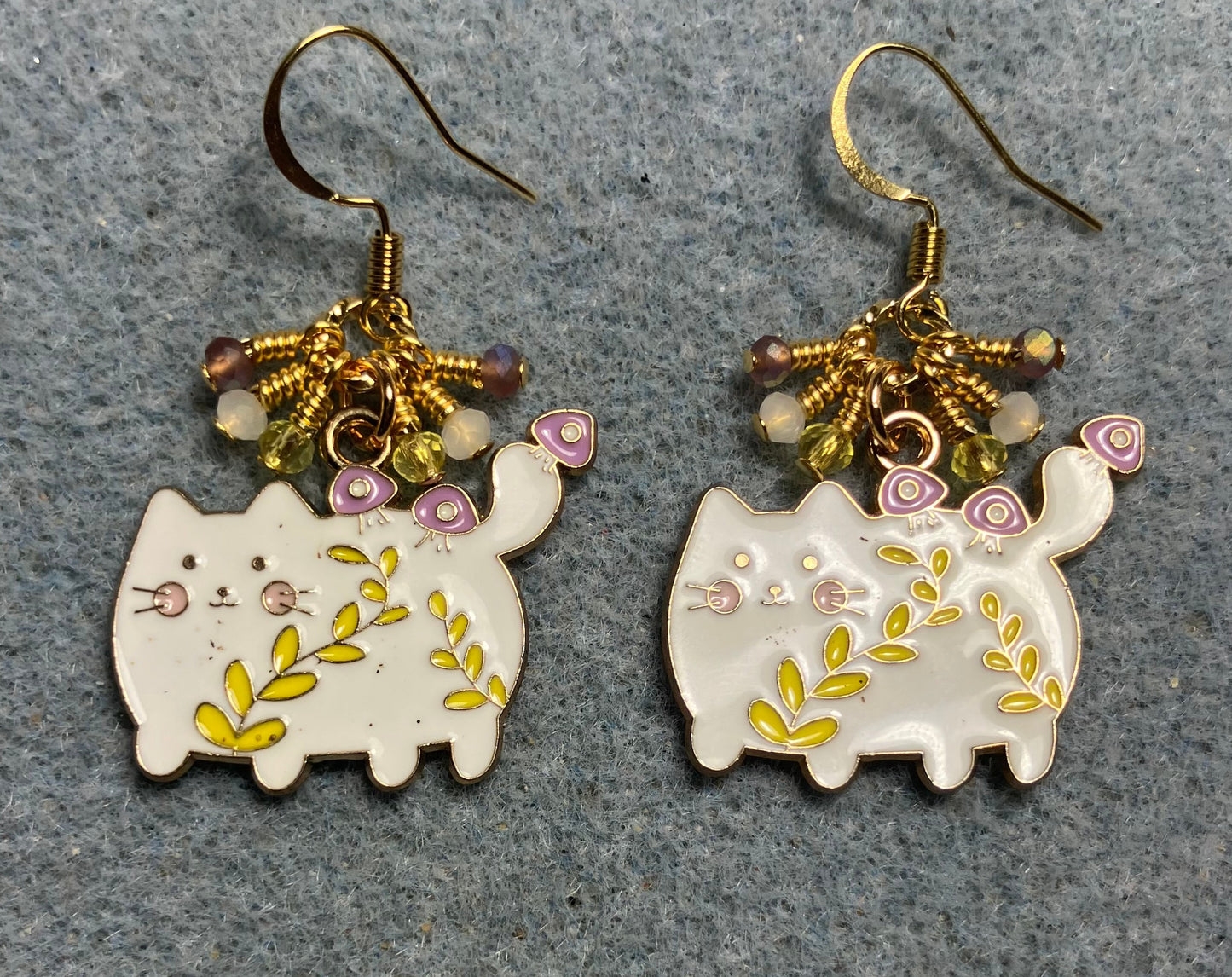 White, yellow, and violet enamel cowboy cat charm earrings adorned with tiny dangling white, yellow, and violet Chinese crystal beads.