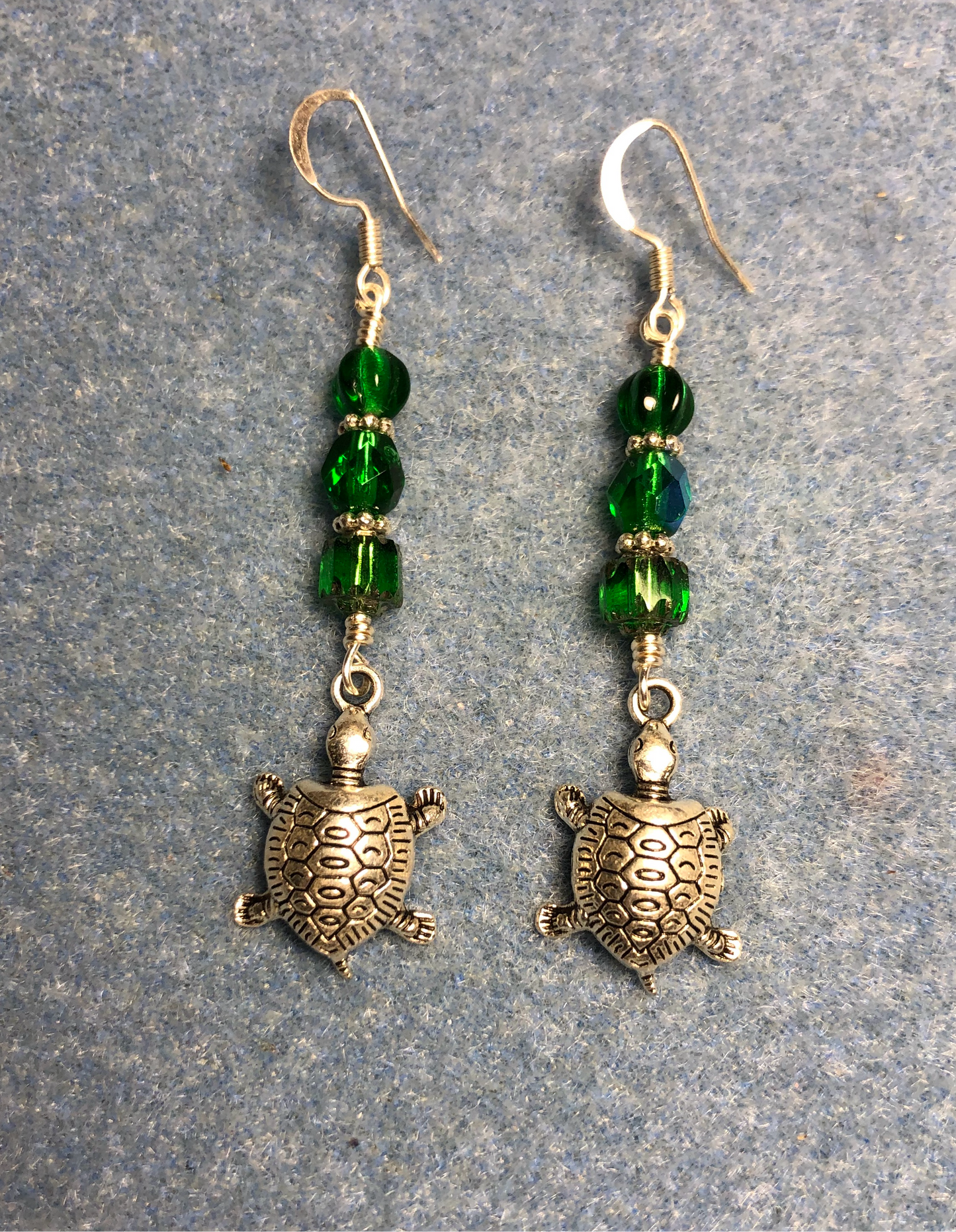 Silver turtle charm earrings adorned with emerald green Czech glass beads