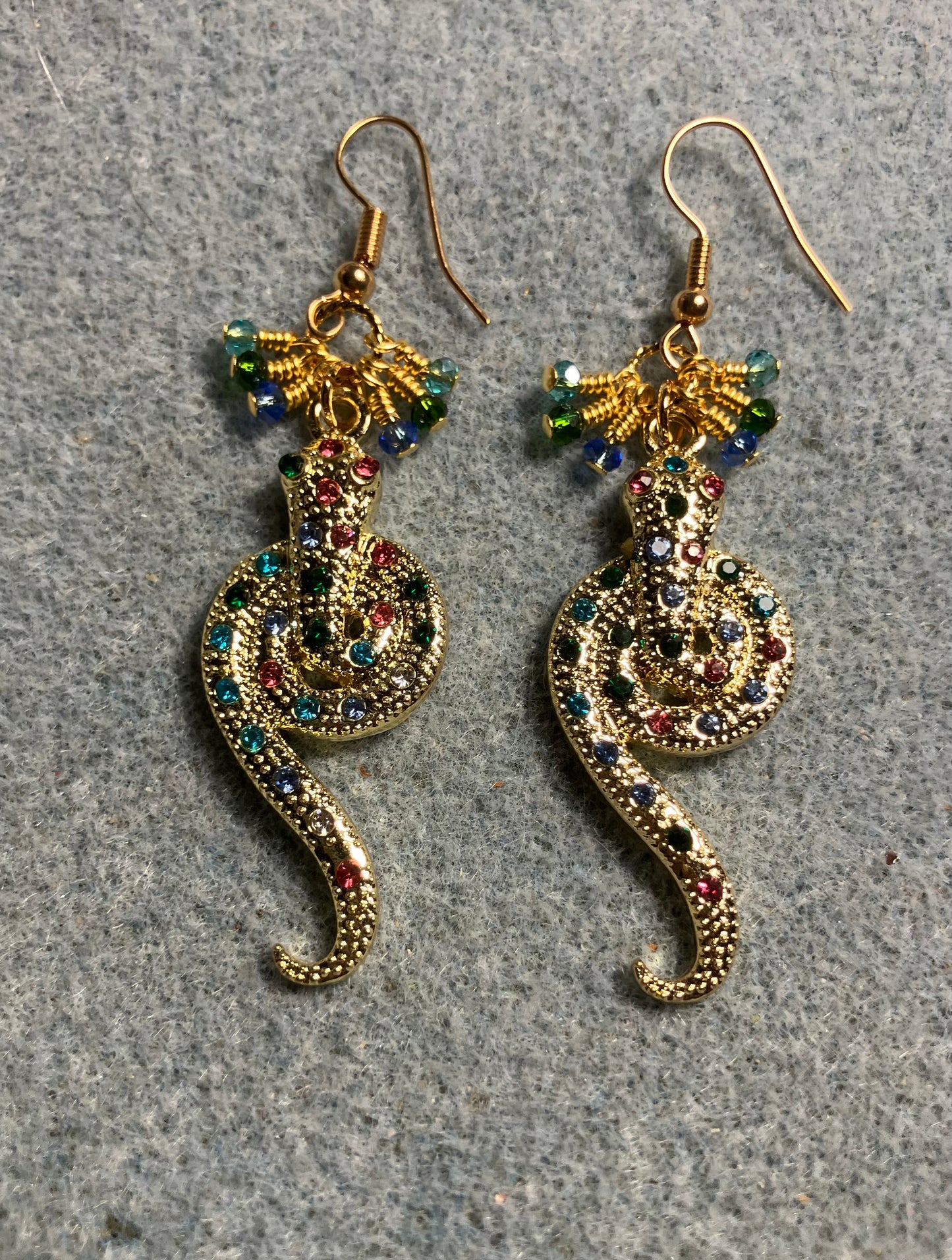 Gold and colored rhinestone coiled snake charm earrings adorned with tiny dangling turquoise, light blue, and dark green Chinese crystal beads.