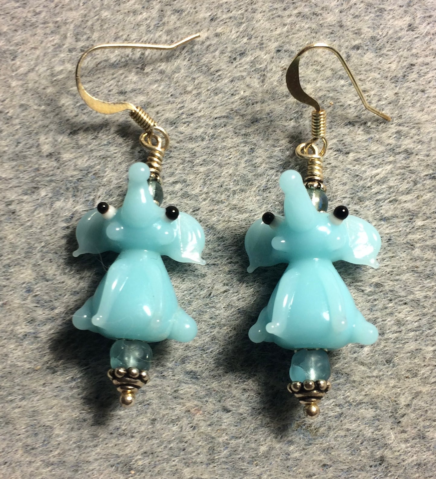 Opaque light aqua lamp work sitting elephant bead earrings adorned with light aqua Czech glass beads.