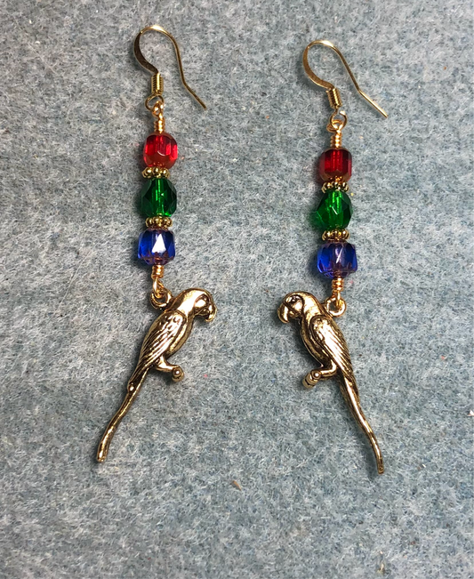 Gold macaw feather earrings adorned with dark blue, emerald green, and red Czech glass beads