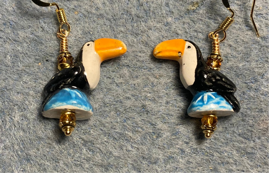 Small black, white, blue, and tangerine ceramic toucan bead earrings adorned with tangerine Chinese crystal beads.