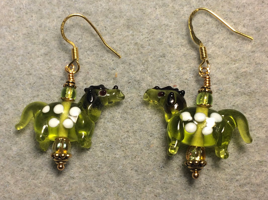 Translucent olive green and white lamp work spotted horse bead earrings adorned with olive green Czech glass beads.