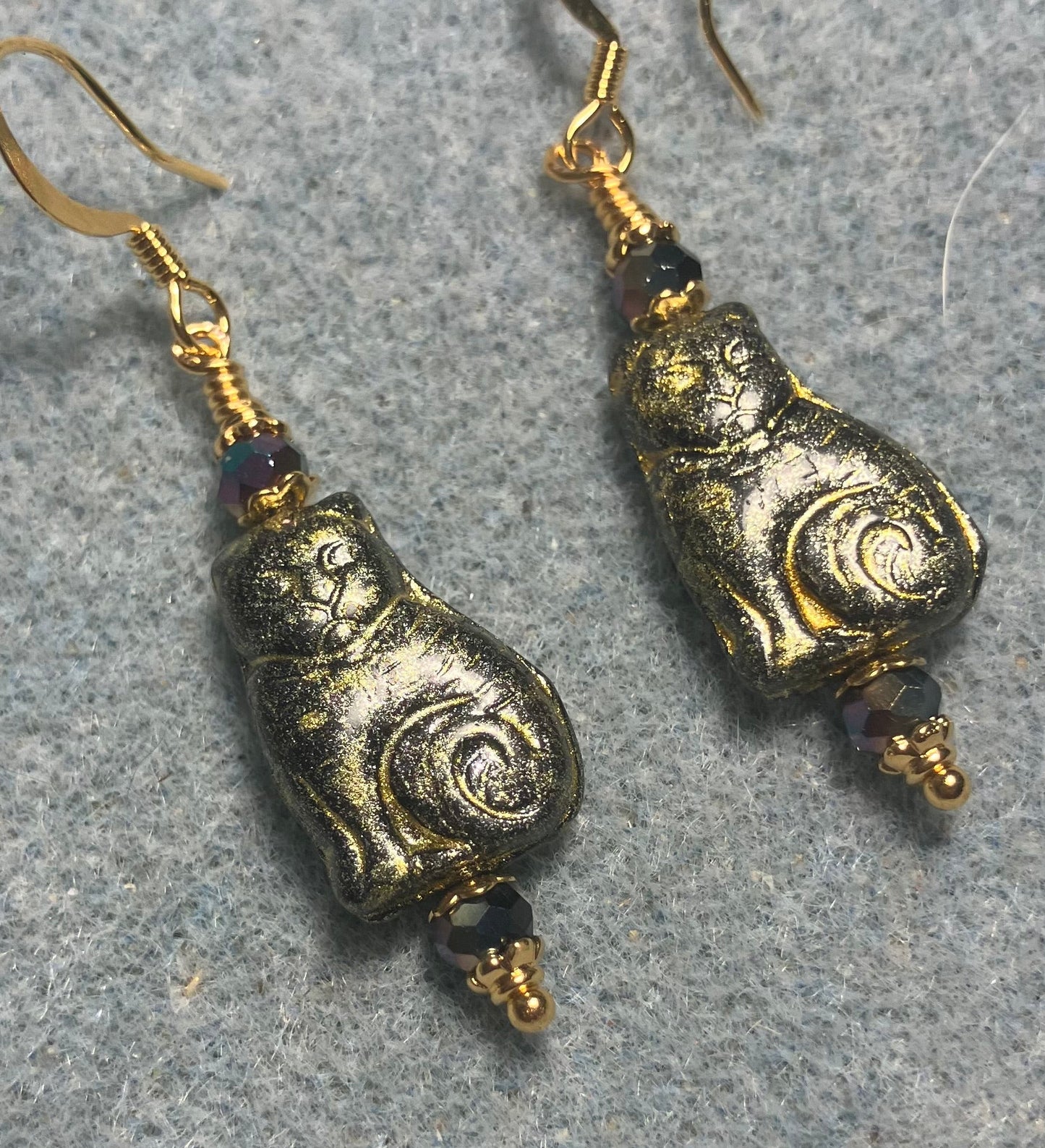 Medium black (with gold wash) Czech glass cat bead earrings adorned with black Chinese crystal beads.