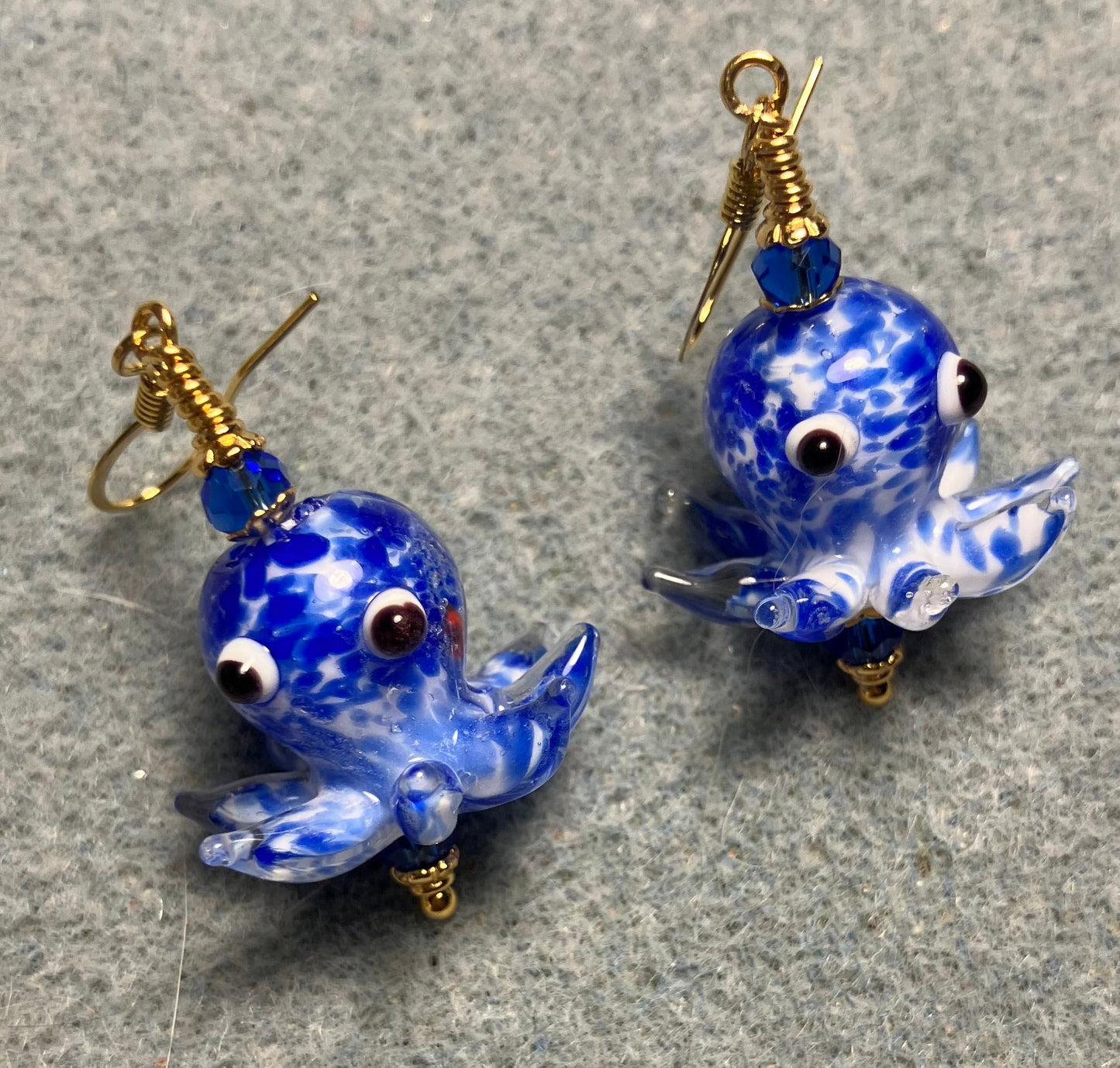 Bright blue and white mottled lamp work octopus bead earrings adorned with bright blue Chinese crystal beads.