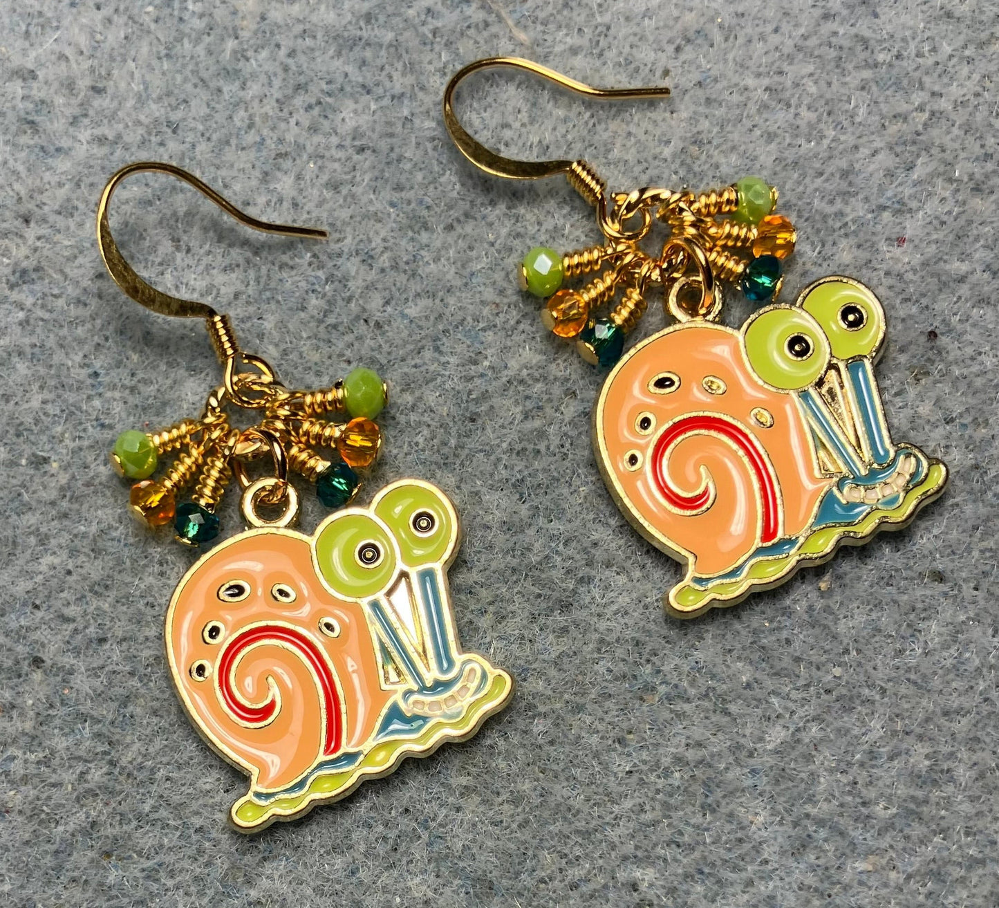 Orange, green, and turquoise enamel snail charm earrings adorned with tiny dangling orange, green, and turquoise Chinese crystal beads.