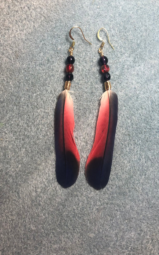 Very rare purple and red dusky Pionus feather earrings adorned with purple and red Czech glass beads.