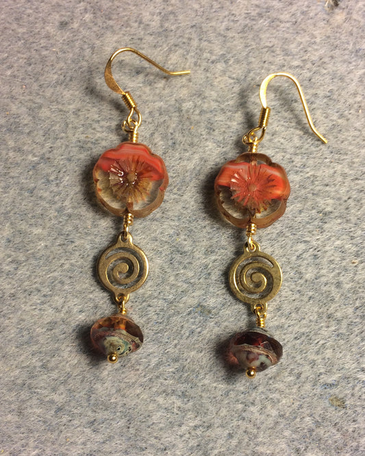 Coral Czech glass pansy bead earrings adorned with gold swirly connectors and coral Czech glass Saturn beads.