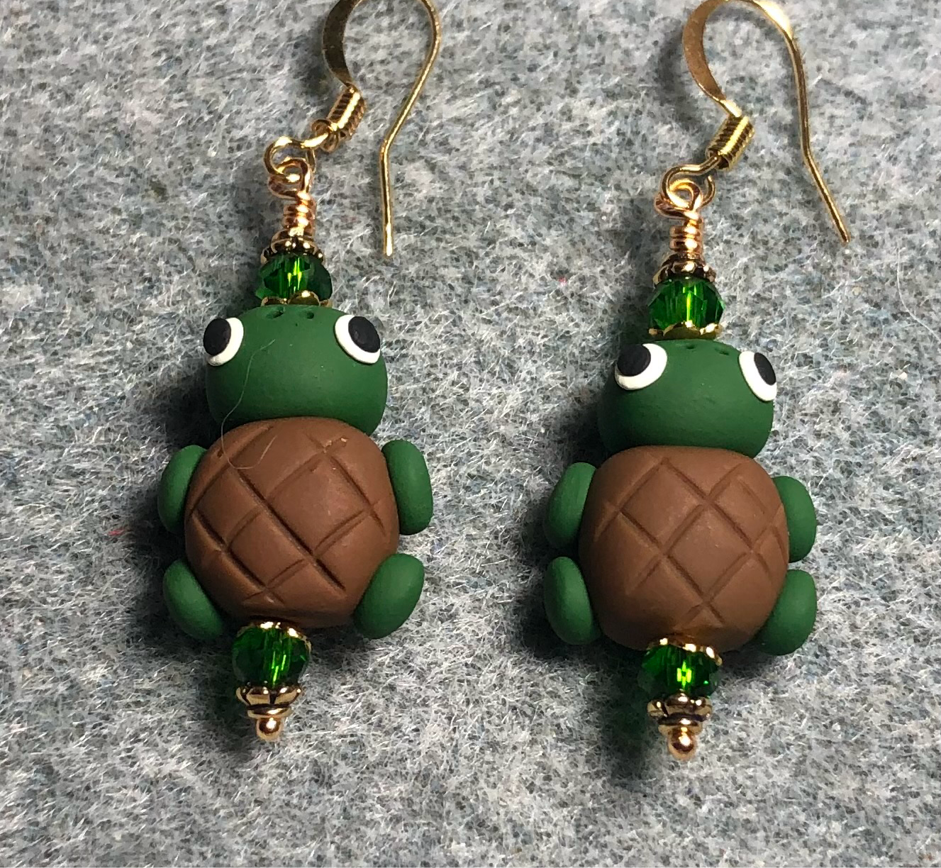 Green and brown polymer clay turtle bead earrings adorned with green Chinese crystal beads.