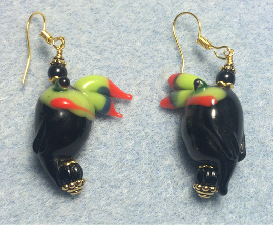 Black, green, and red lamp work toucan bead earrings adorned with black Czech glass beads.