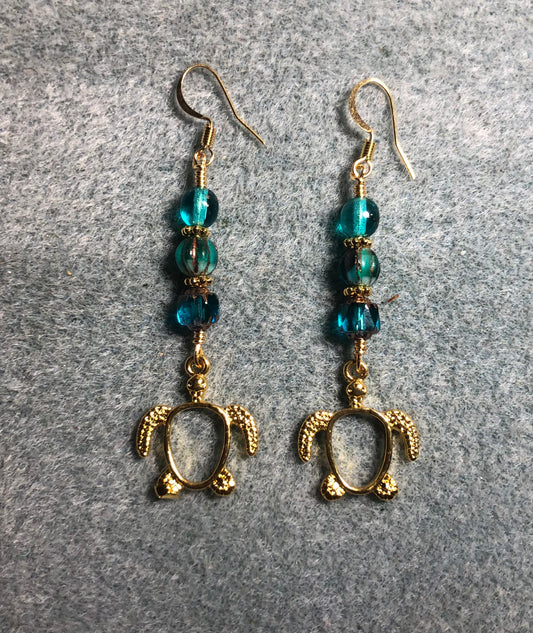 Gold turtle charm earrings adorned with turquoise Czech glass beads.