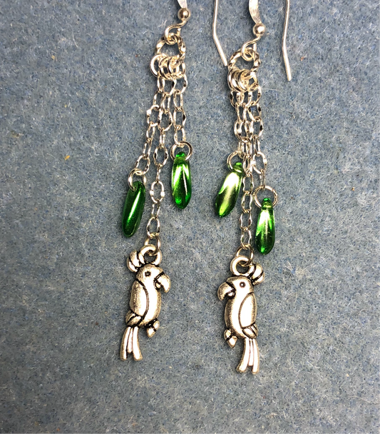 Small silver parrot charm earrings attached to silver chain and adorned with small metallic green Czech glass lentil beads
