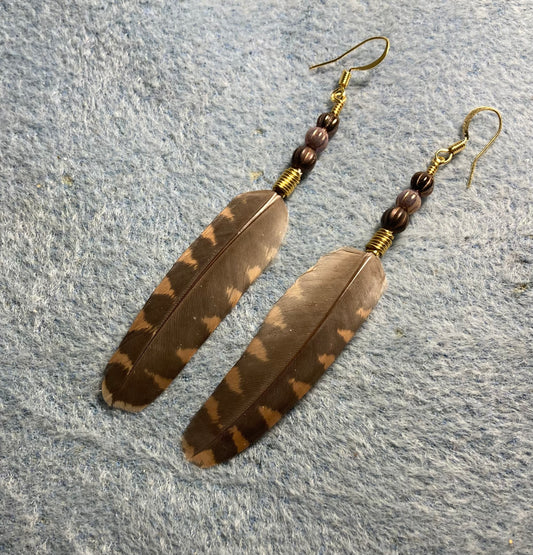 Brown and tan striped woodcock feather earrings adorned with brown and tan Czech glass beads.