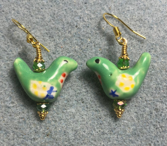 Small green, yellow, and blue ceramic bird bead earrings adorned with green Chinese crystal beads.